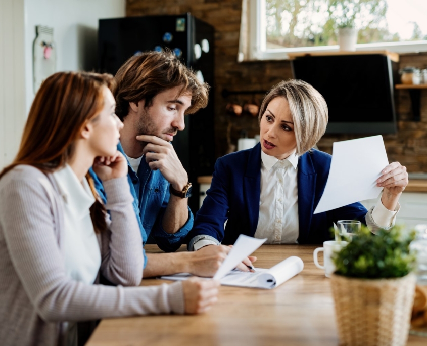 Insurance Agent Talking To A Couple About Terms Of Their Lease A